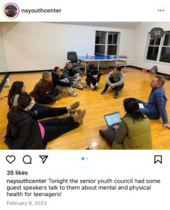 Screenshot of Instagram post by "nayouthcenter." Photo of young people sitting on the floor in a circle with 91Ů facilitator. Caption: "tonight the senior youth council had some guest speakers talk to them about mental and physical health for teenagers!" Dated February 8, 2023.